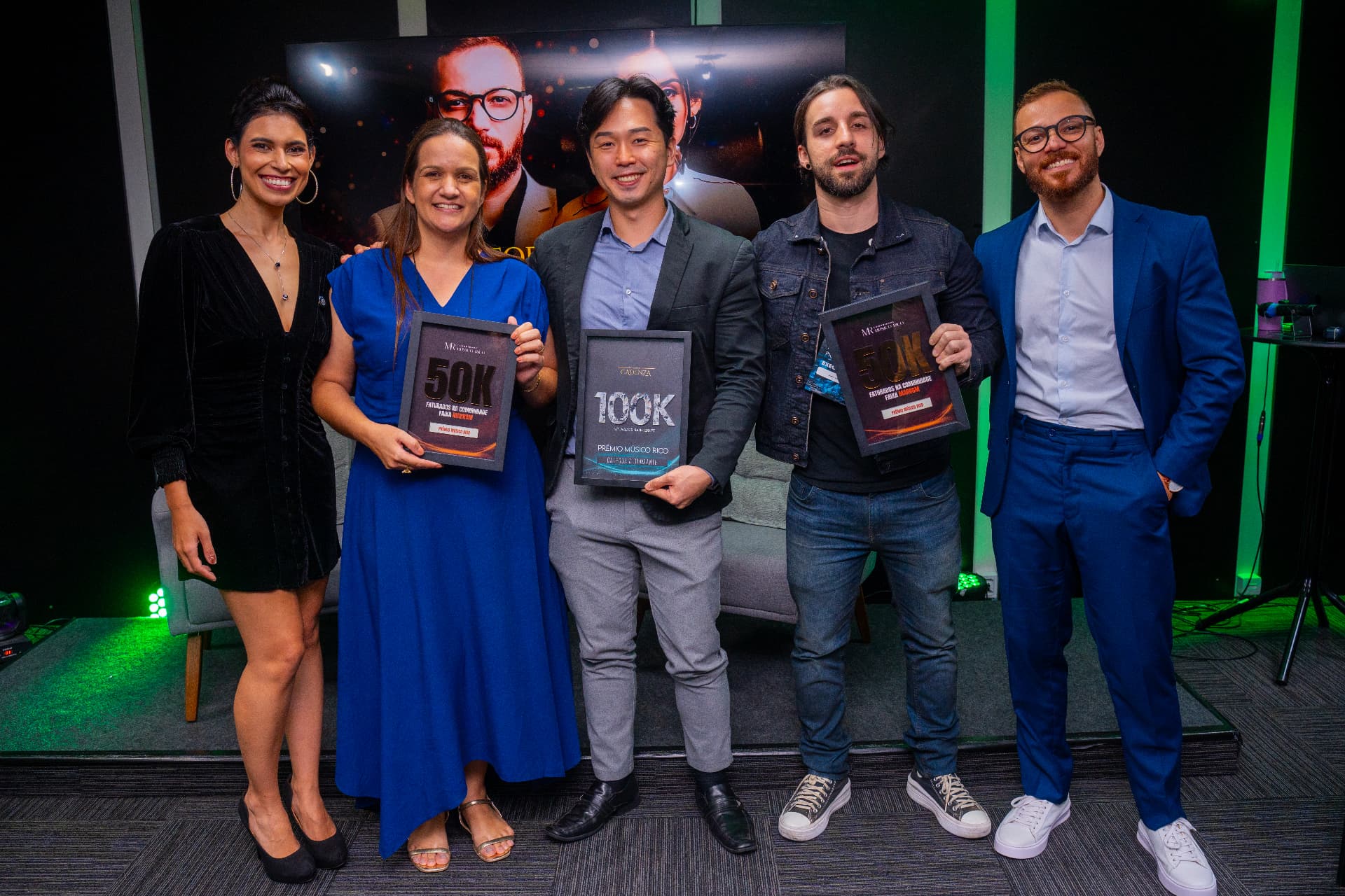 Grupo de participantes segurando placas de reconhecimento de faturamento