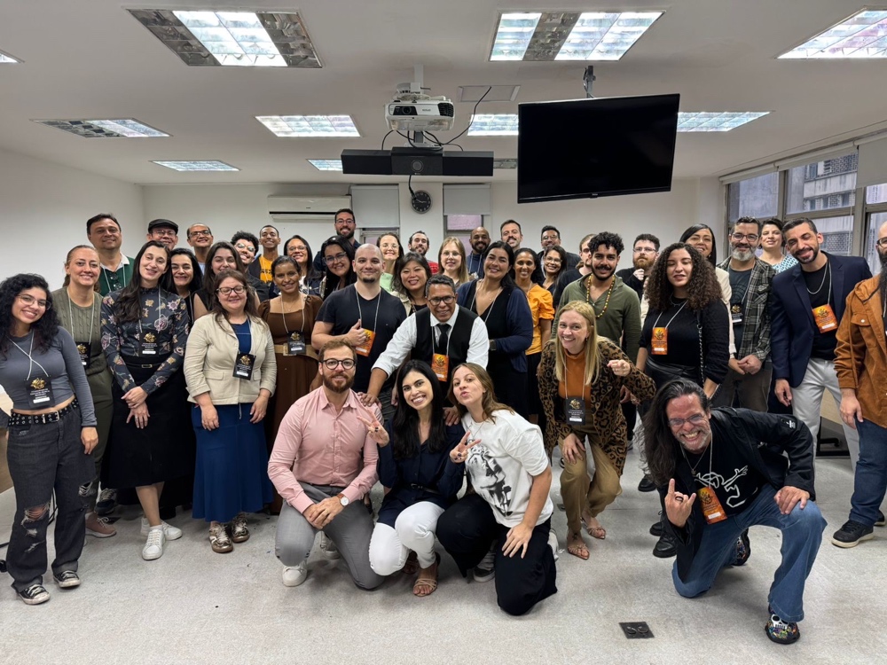 Foto coletiva dos participantes comemorando com os braços levantados